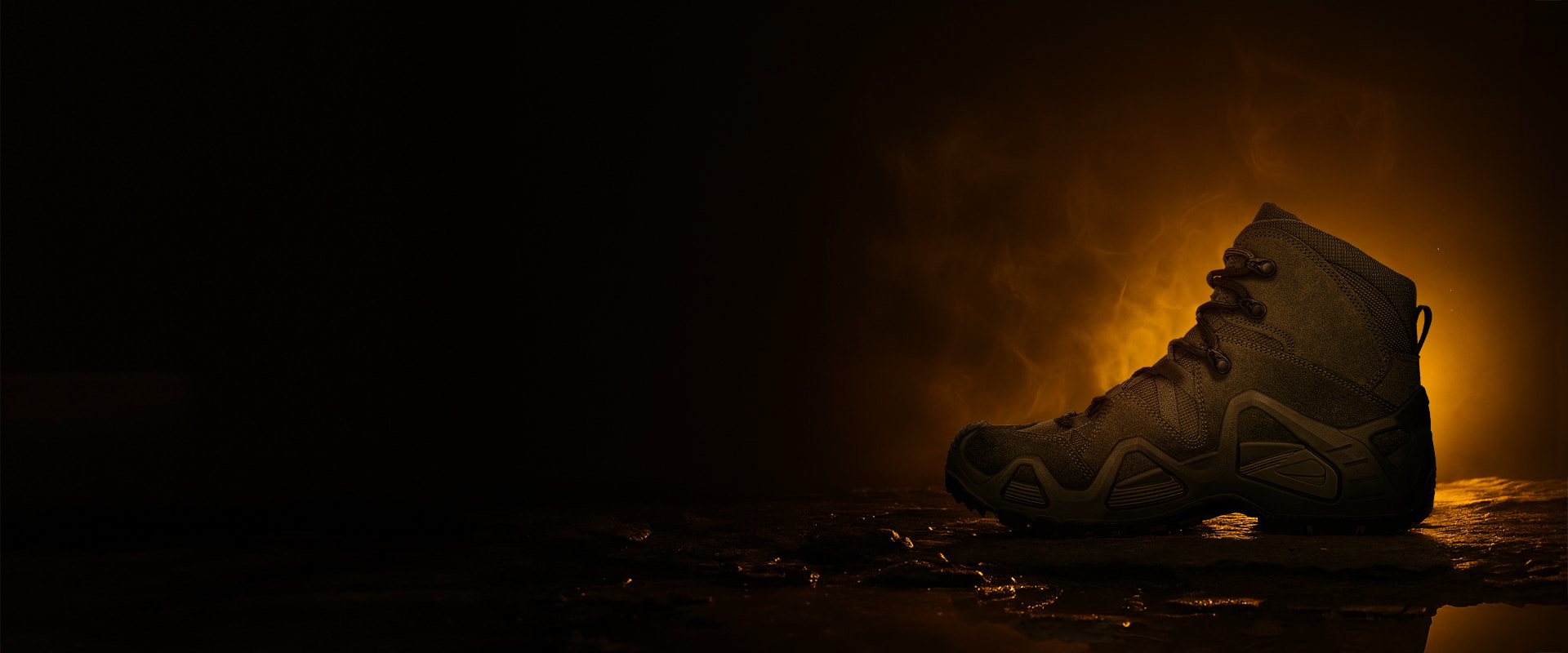 Black shoe dimly lit against a black background.