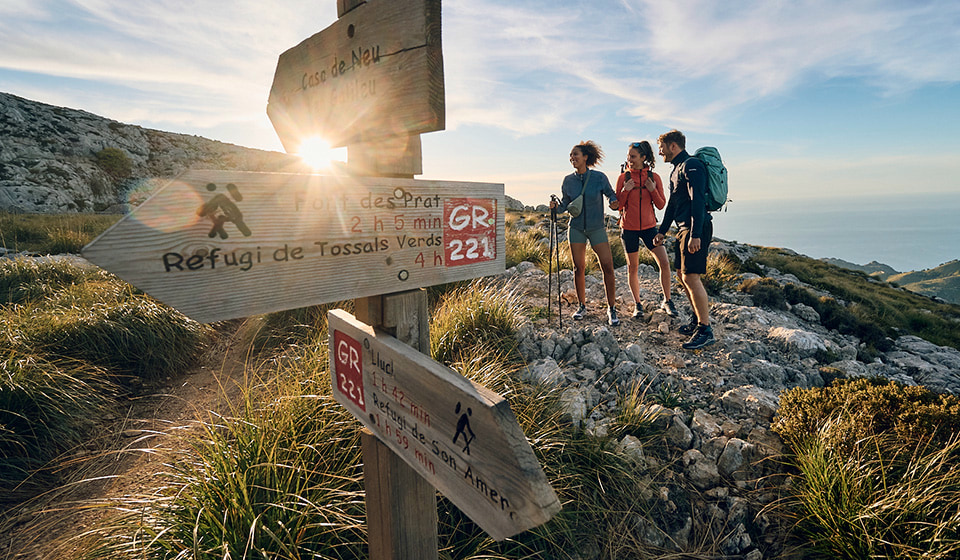 People with bouquets of flowers at a parade. A man cheers with a raised fist.