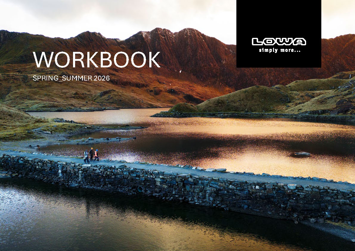 Due escursionisti su un sentiero di montagna davanti a un cielo nuvoloso con il logo LOWA e l\'hashtag #ForTheNextStep.