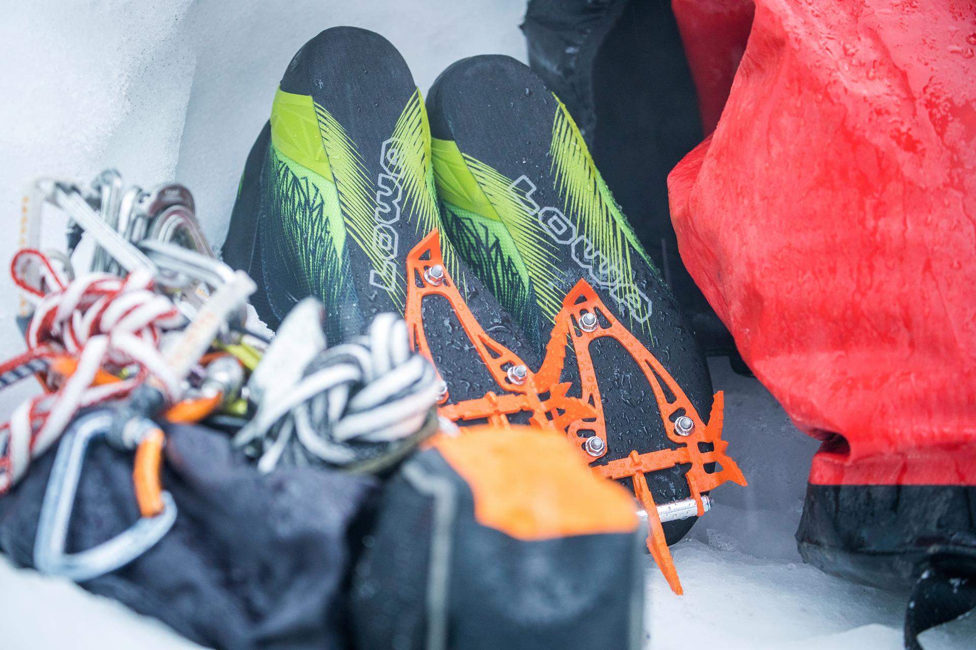 Ice tool shoes with crampons and climbing utensils in snow.