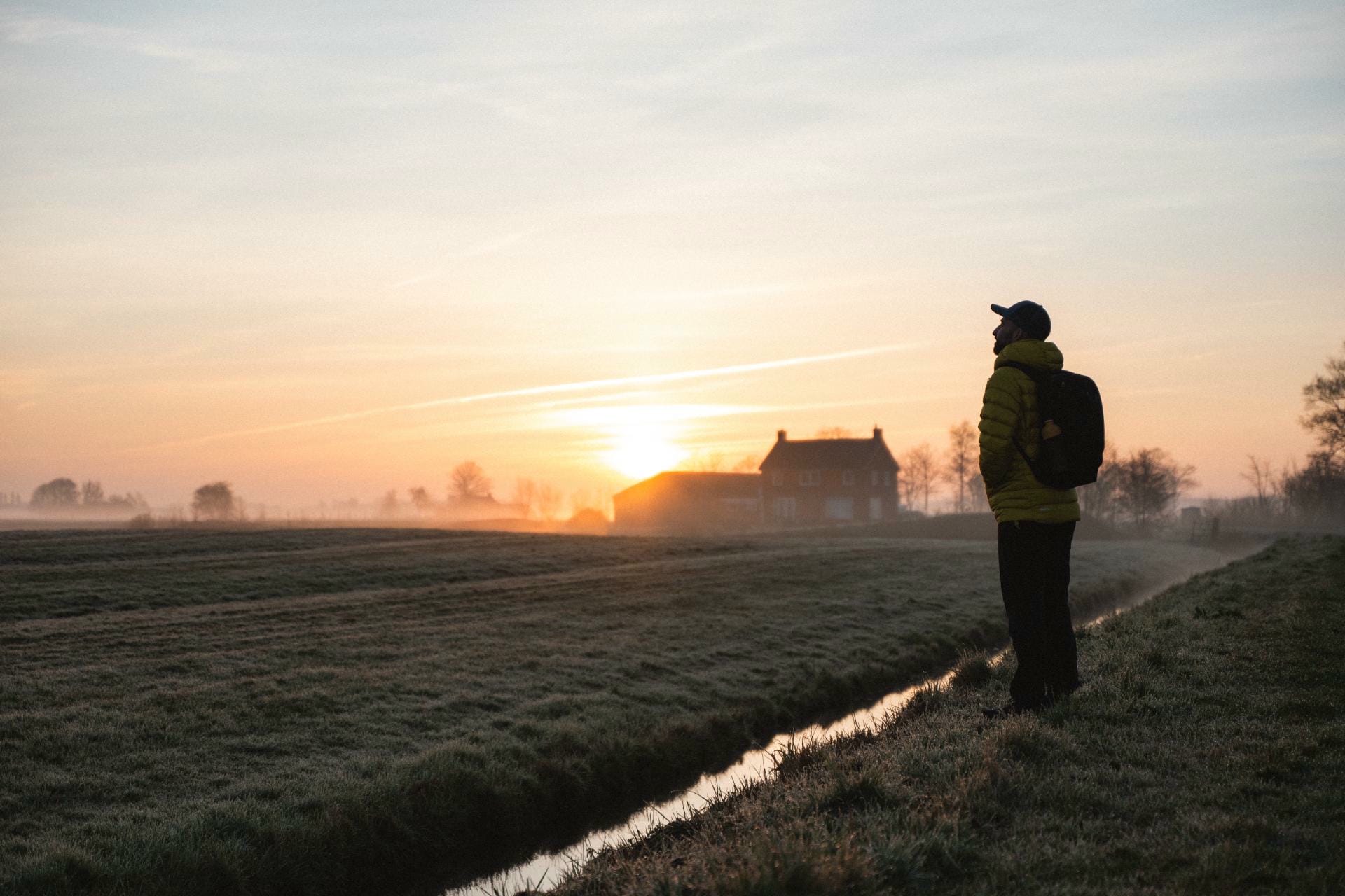 Primo piano di un uomo che si allaccia gli scarponi da trekking. primo piano di scarpe e mani nell\'erba.