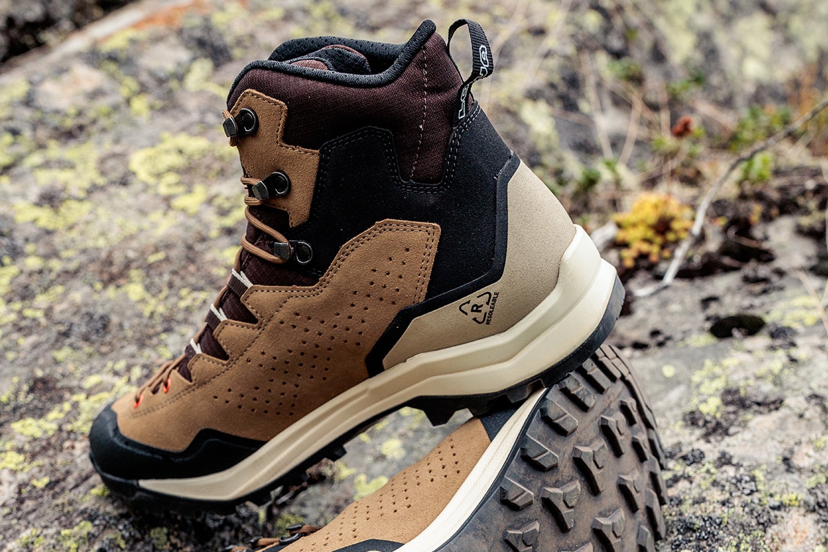Nahaufnahme eines braunen LOWA EXPLORER GTX MID auf steinigem Untergrund mit Moos.